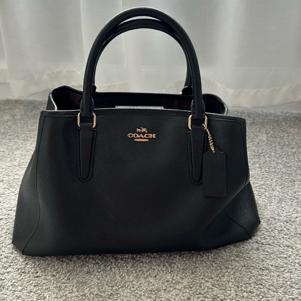 Black Coach leather handbag with crossbody strap.